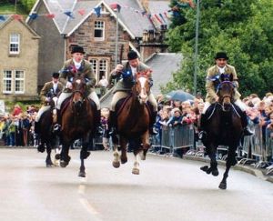Riders returning from riding the Selkirk Marches gallop in at The Toll ~ Public Domain ~ https://en.wikipedia.org/wiki/Common_Riding#/ media/File:Thetoll.jpg